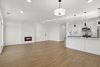 A modern kitchen with a fireplace and wooden floors. at Terraces at High Mountain, Alabama